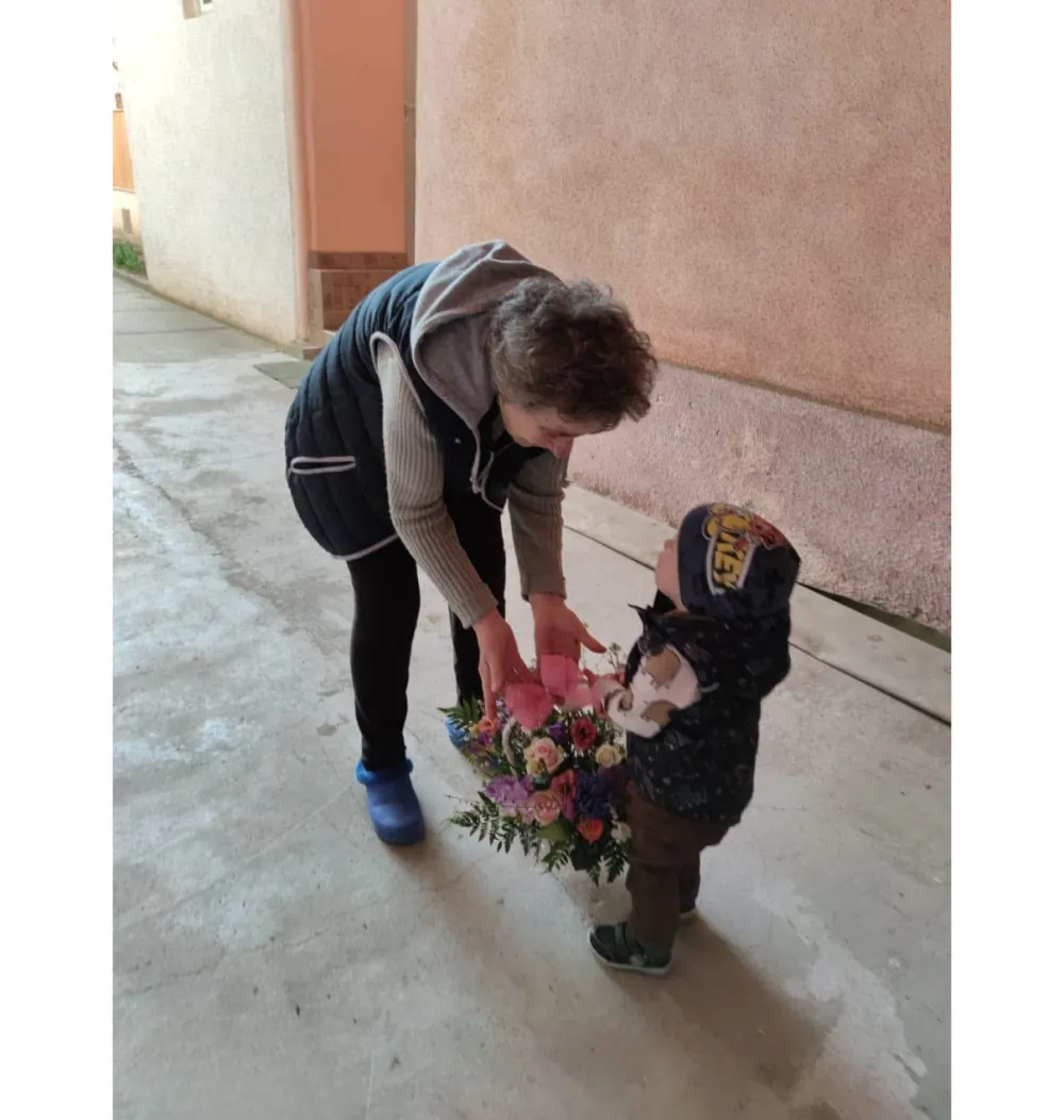Kundin übergibt personalisierten Blumenstrauß an Kind