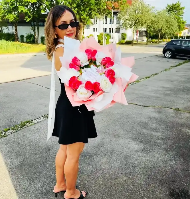 Raluca, Gründerin von Dandelion 11:11 aus Bad Wörishofen, mit einem großen Strauß aus rosa und weißen Rosen