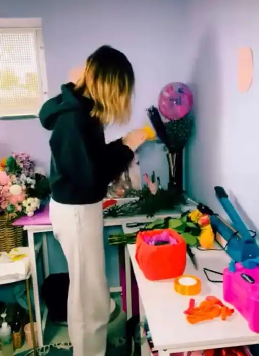 Raluca von Dandelion 11:11 hält eine handgefertigte schwarze Geschenkverpackung mit goldener Silhouette – exklusive Verpackungsgestaltung aus Bad Wörishofen