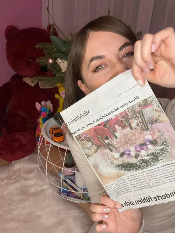 Raluca, Inhaberin von Dandelion 11:11, mit dem Zeitungsartikel der Mindelheimer Zeitung über ihren preisgekrönten Adventskranz